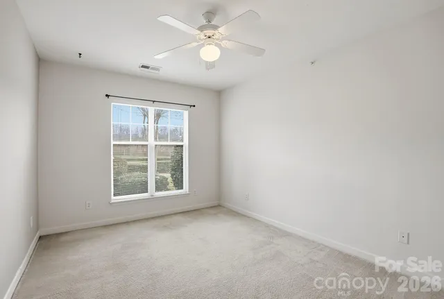an empty room with closet and a ceiling fan
