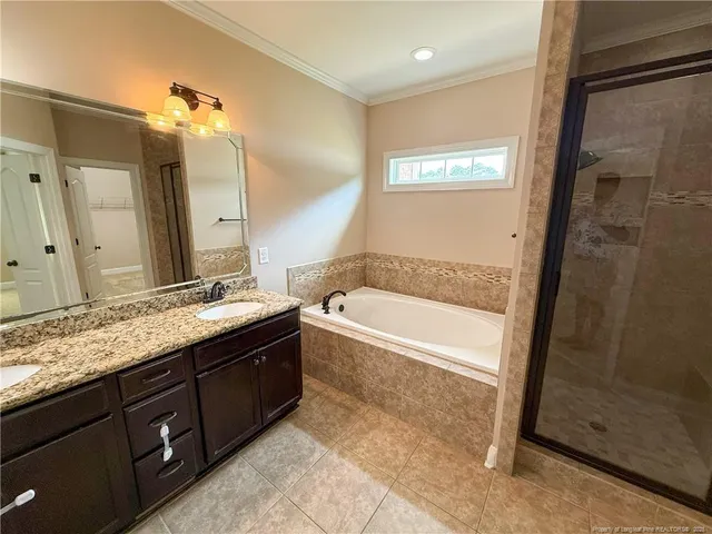 a spacious bathroom with a granite countertop sink a mirror and a tub