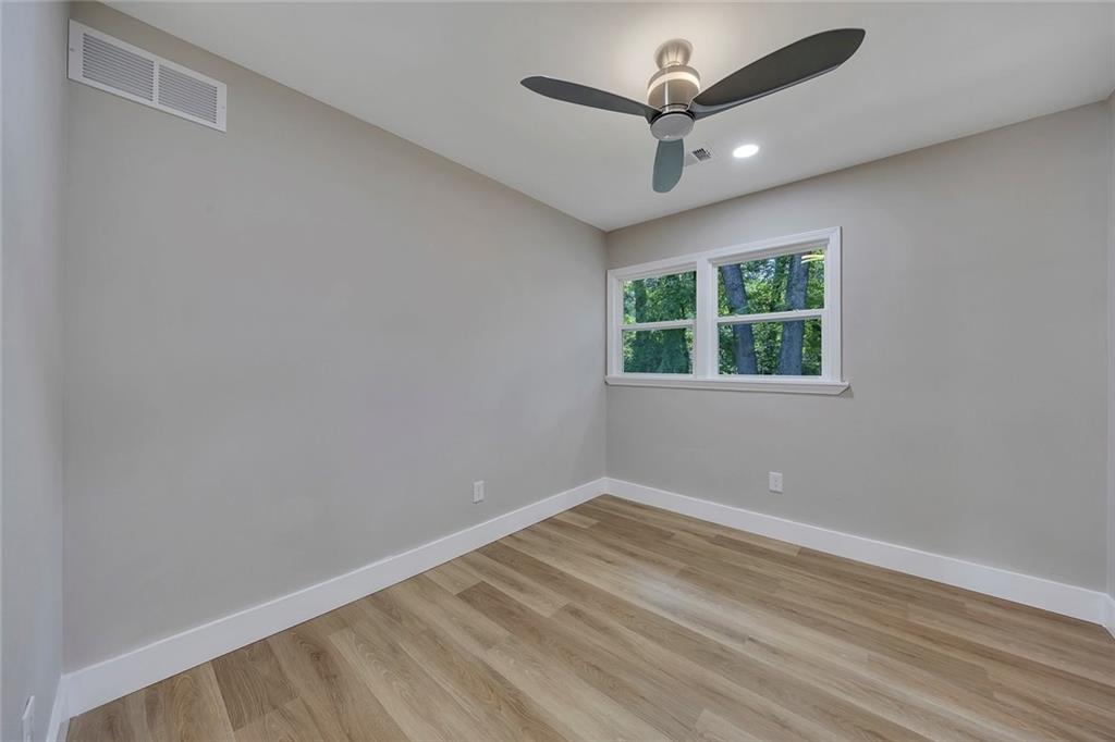 202 Oakcliff Court Northwest Atlanta, GA 30331 - Photo 14 of 27 an empty room with a ceiling fan and windows