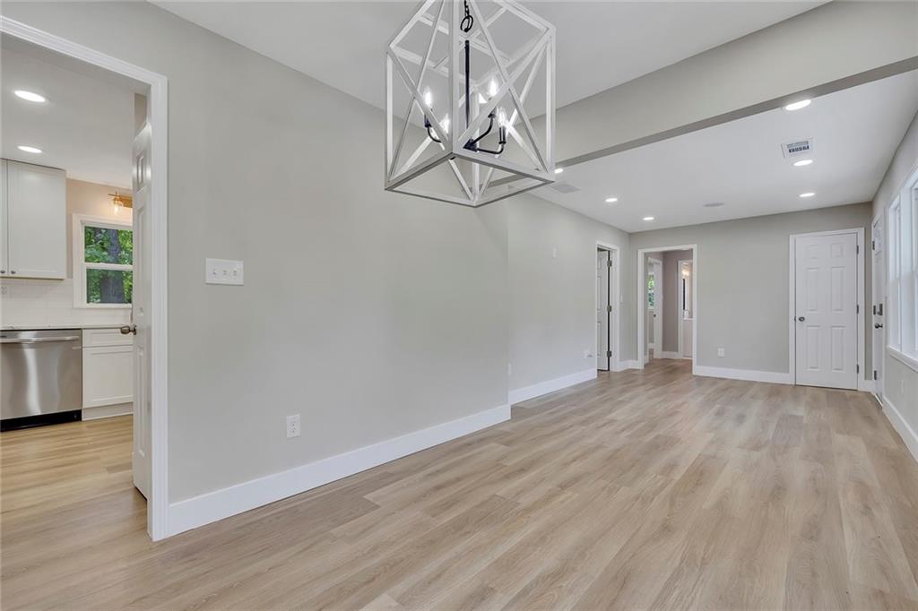 202 Oakcliff Court Northwest Atlanta, GA 30331 - Photo 7 of 27 a view of empty room with wooden floor and kitchen view