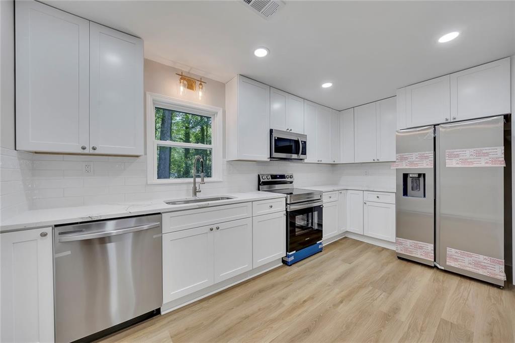 202 Oakcliff Court Northwest Atlanta, GA 30331 - Photo 8 of 27 a kitchen with white cabinets and appliances