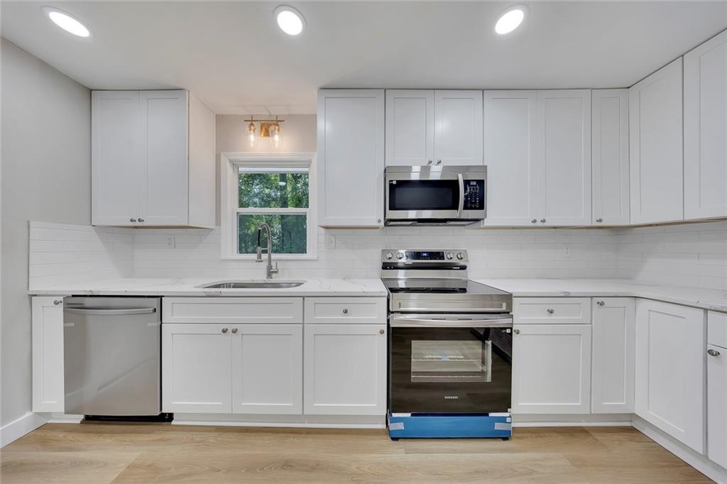 202 Oakcliff Court Northwest Atlanta, GA 30331 - Photo 9 of 27 a kitchen with stainless steel appliances granite countertop a stove a sink and a microwave