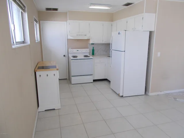 a kitchen with cabinets a refrigerator and a stove