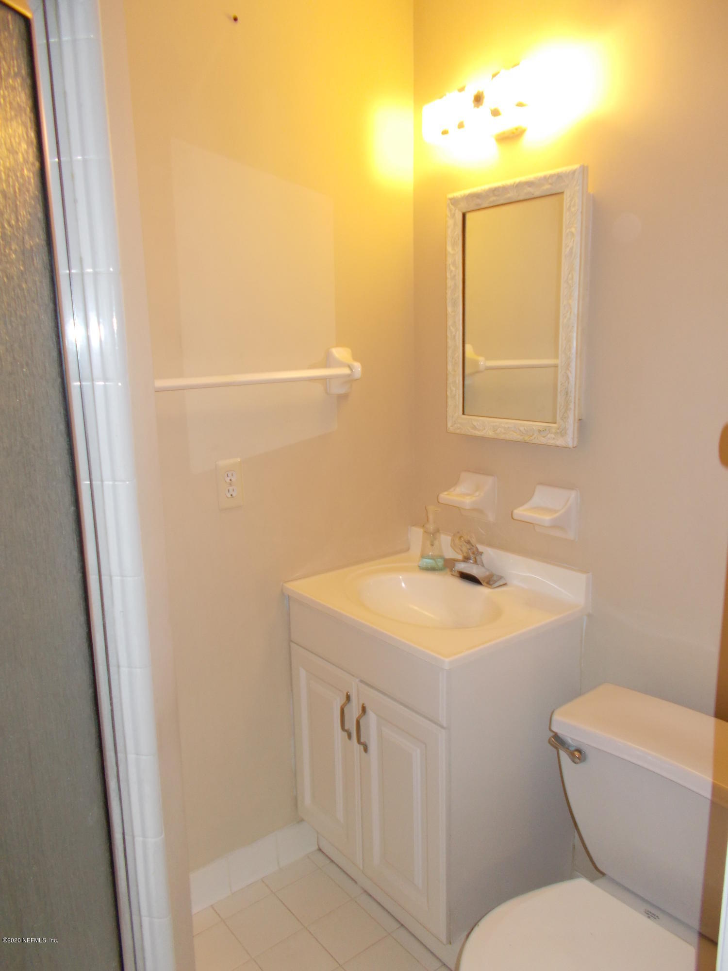 1500 First Street, Unit B Neptune Beach, FL 32266 - Photo 8 of 13 a bathroom with a toilet a sink a vanity and mirror