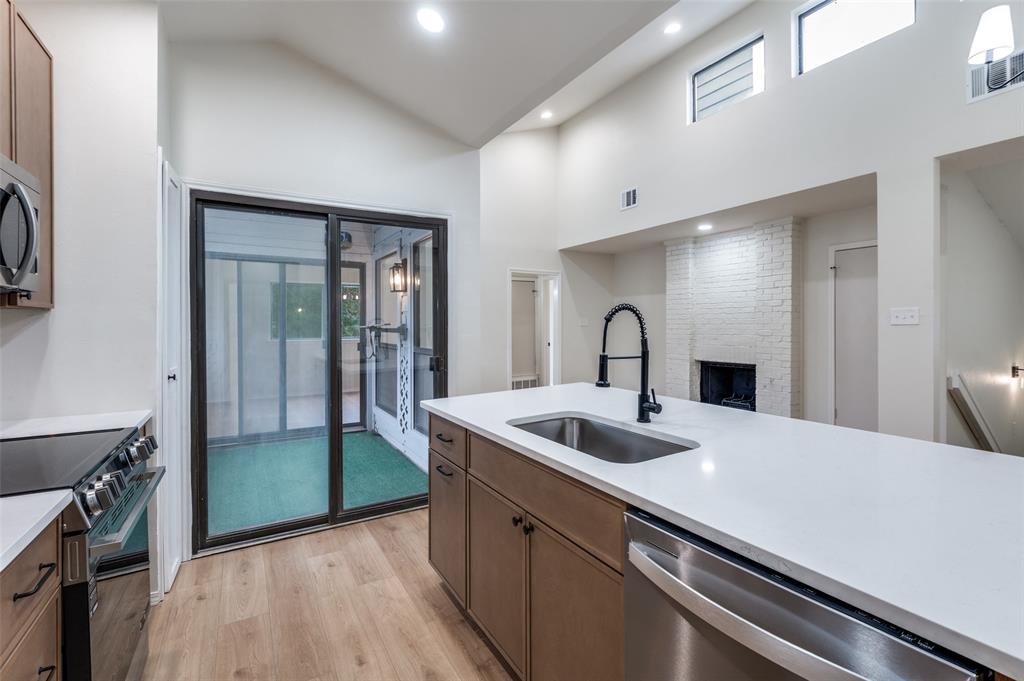 17490 Meandering Way, Unit 2202 Dallas, TX 75252 - Photo 16 of 24 Modern kitchen island featuring a stainless steel sink, black faucet, and white countertop