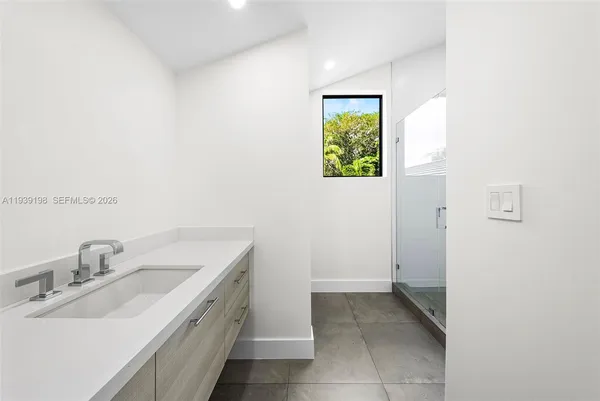 a front view of a house with a garden and tree