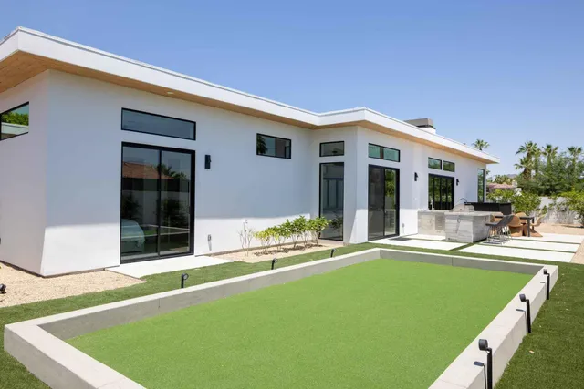 a backyard of a house with table and chairs