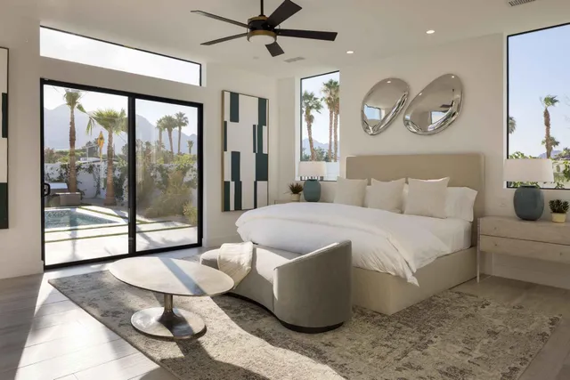 a spacious bedroom with a bed and glass window