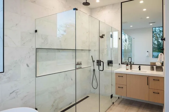a bathroom with a double vanity sink mirror and shower