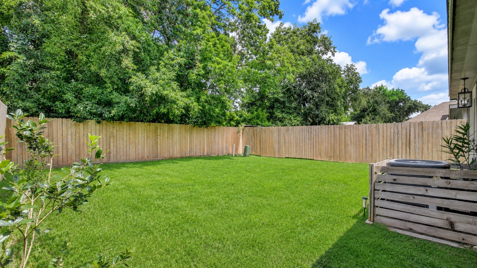 8647 Suburban Oaks Road Houston, TX 77093 - Photo 21 of 21 The fenced yard continues with nearby mature trees, adding shade and depth to the outdoor space. (photo has been enhanced for marketing purposes)