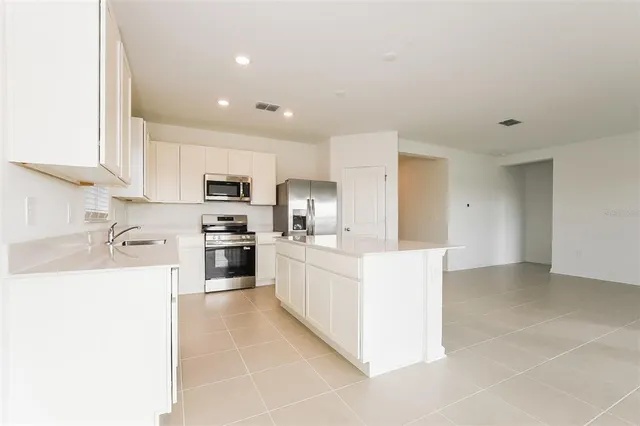 a kitchen with granite countertop white cabinets and stainless steel appliances