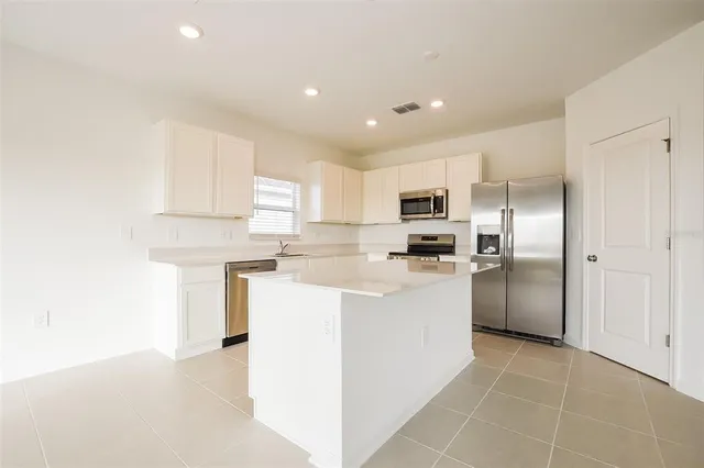 a kitchen with cabinets and stainless steel appliances