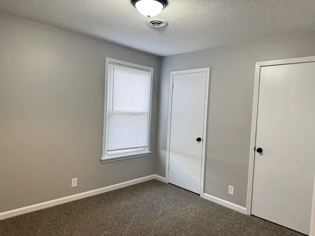 an empty room with windows and closet