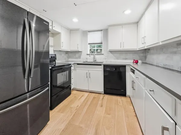 a kitchen with granite countertop a refrigerator stove top oven and sink