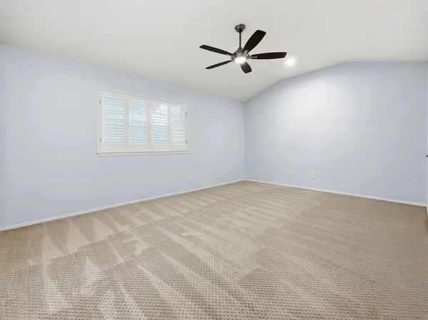an empty room with a window and a fan