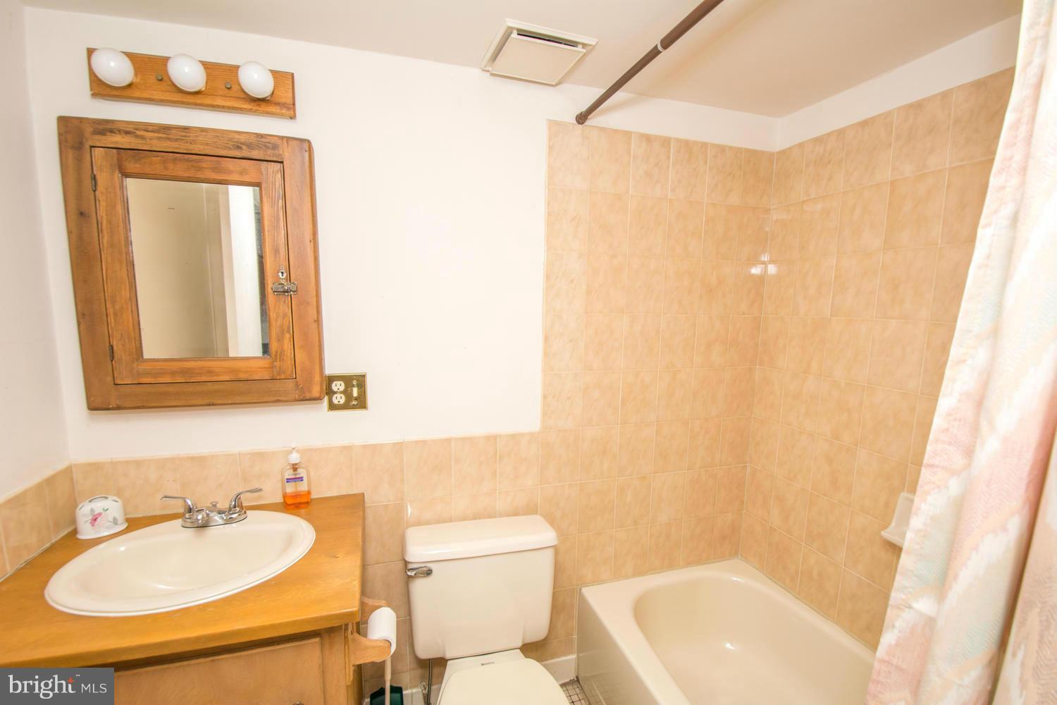 10 Mallow Hill Road Baltimore, MD 21229 - Photo 27 of 30 a bathroom with a toilet sink vanity tub and mirror