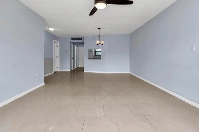 an empty room with a ceiling fan and window