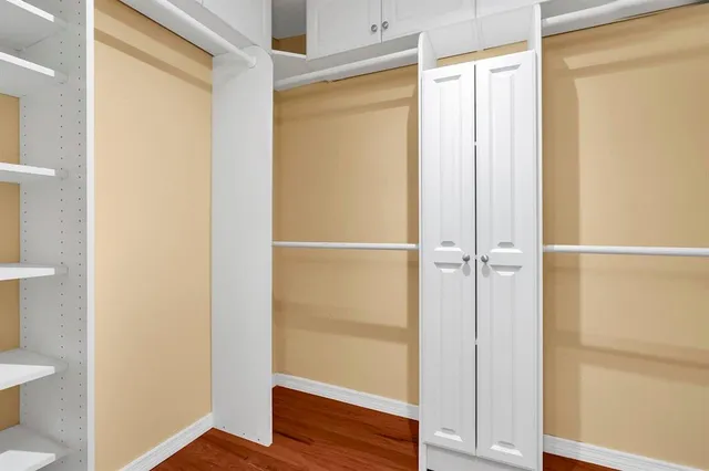 a view of walk in closet with wooden floor