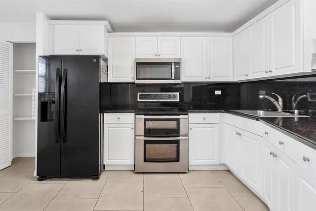 a kitchen with cabinets stainless steel appliances and a sink