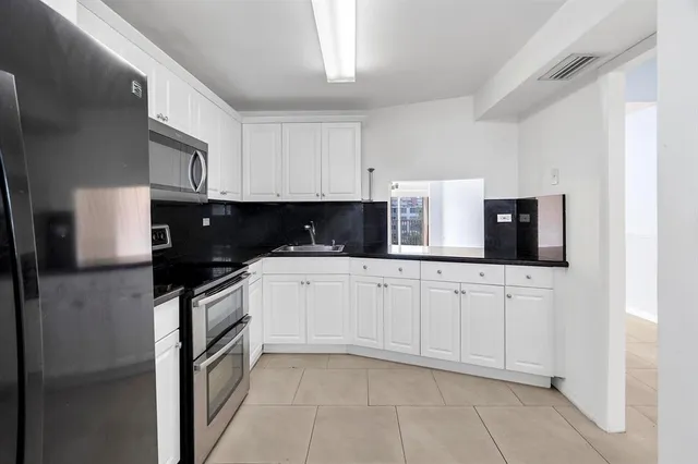 a view of a kitchen with stainless steel appliances cabinets and a window