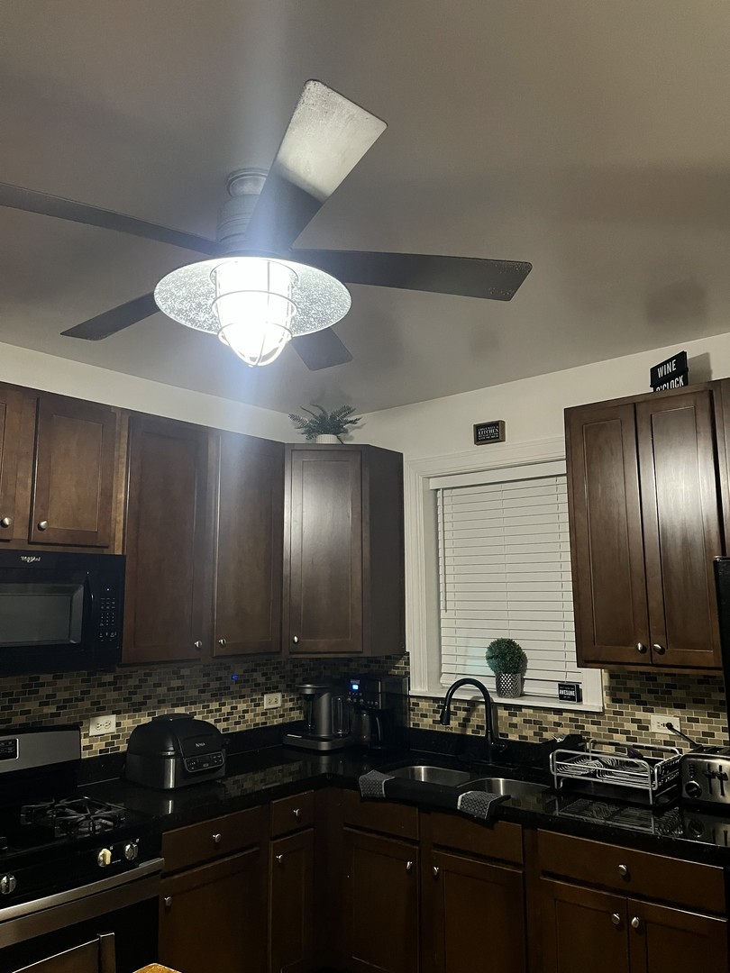 4920 West Monroe Street Chicago, IL 60644 - Photo 4 of 7 a kitchen with stainless steel appliances a sink stove and cabinets