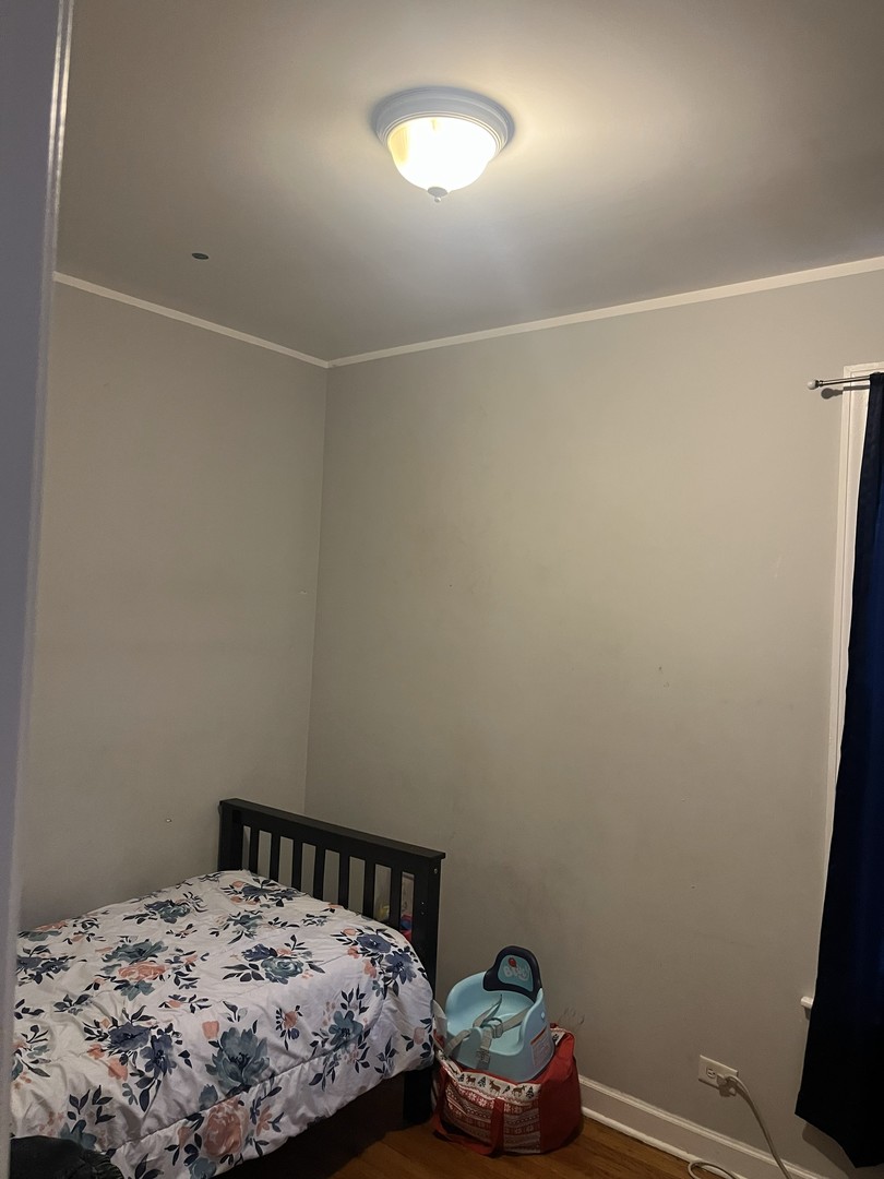 4920 West Monroe Street Chicago, IL 60644 - Photo 6 of 7 a bedroom with a bed and a dresser