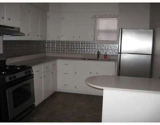 a kitchen with a sink stainless steel appliances and cabinets