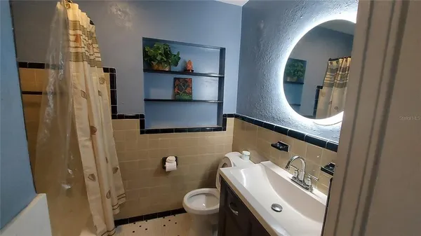a bathroom with a sink a toilet and shower curtain