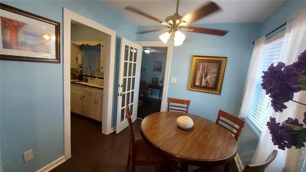 a view of a dining room with furniture and a chandelier fan