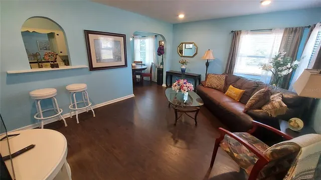 a living room with furniture a window and wooden floor