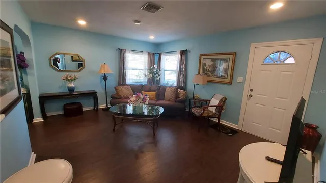a living room with furniture and a wooden floor