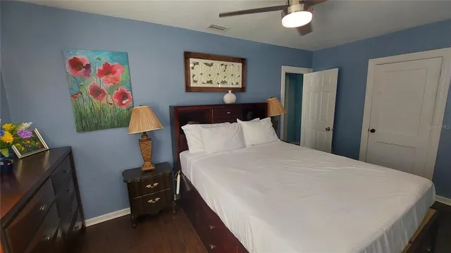a bedroom with a bed and painting on the wall