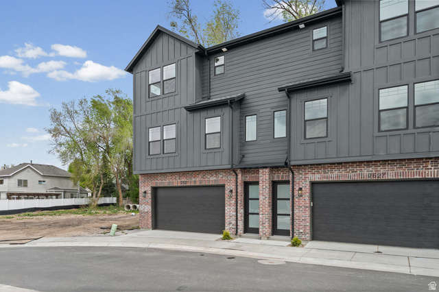 340 East 7635 S Street Sandy, UT 84047 - Photo 26 of 32 View of front of house with board and batten siding, an attached garage, and brick siding