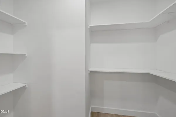 an empty room with wooden floor and a ceiling fan