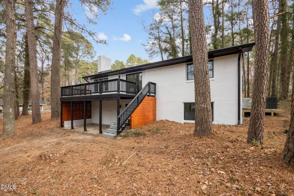 a view of a house with large trees and a yard