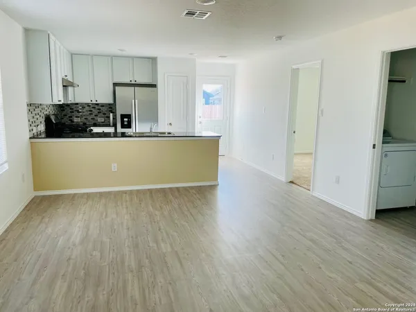 a view of a kitchen with wooden floor and a sink