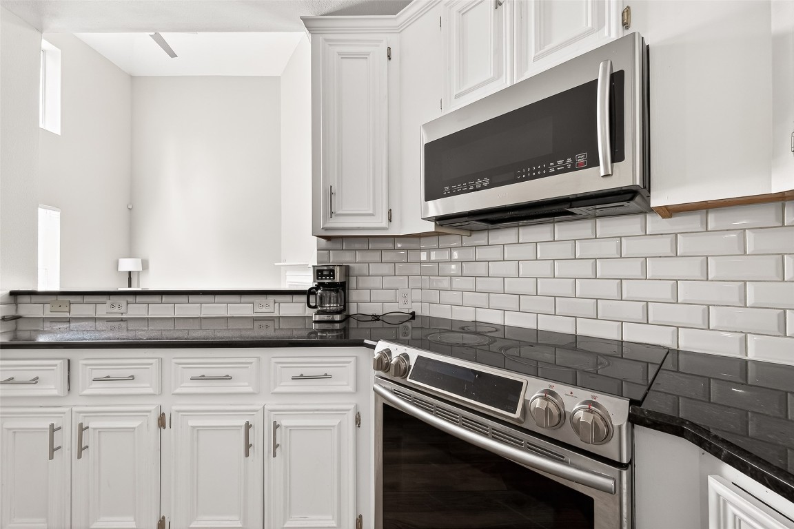 25507 Lyon Springs Court Spring, TX 77373 - Photo 18 of 39 a kitchen with granite countertop a stove microwave and sink