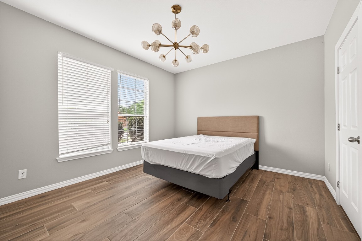 25507 Lyon Springs Court Spring, TX 77373 - Photo 20 of 39 a bedroom with a large bed chandelier and a window
