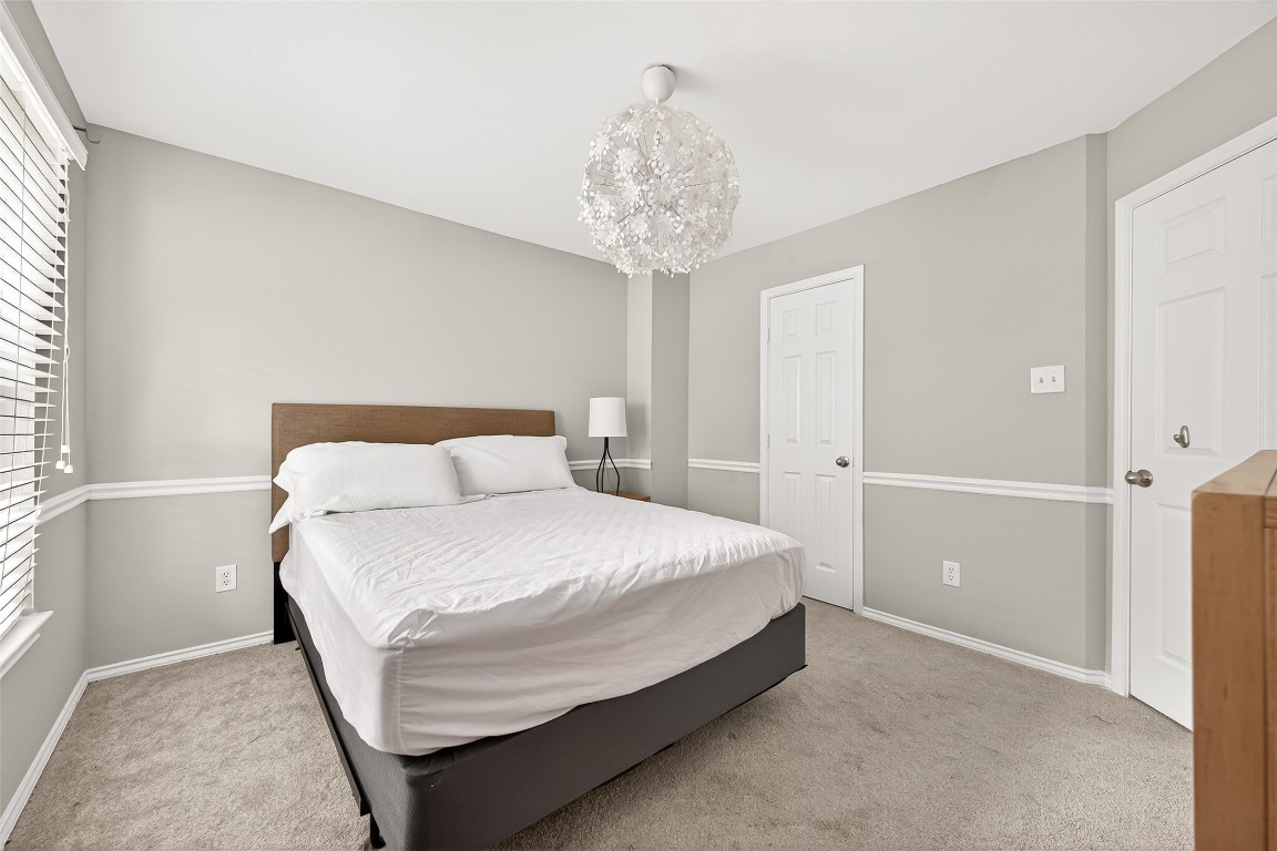 25507 Lyon Springs Court Spring, TX 77373 - Photo 33 of 39 a bedroom with a bed and a chandelier