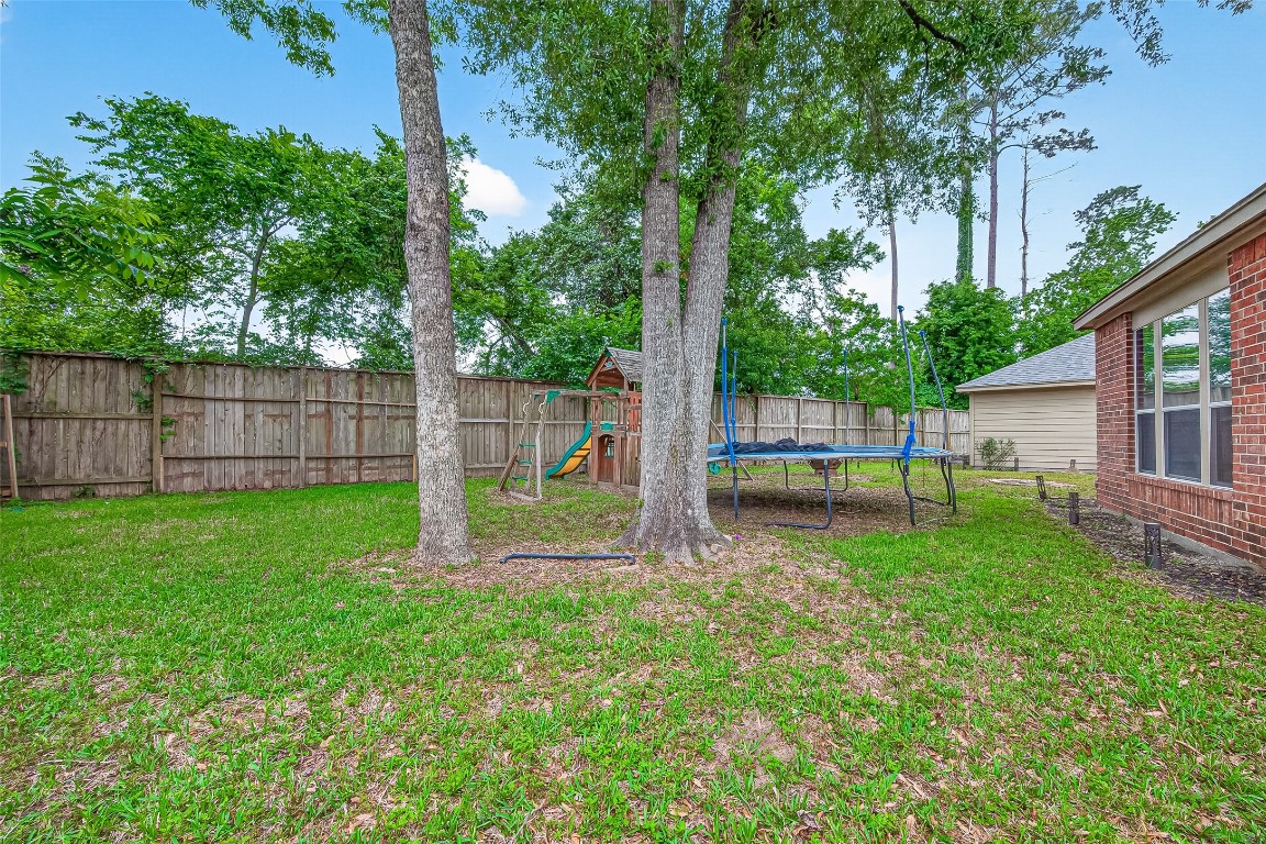 25507 Lyon Springs Court Spring, TX 77373 - Photo 39 of 39 a view of a backyard with a large tree and wooden fence