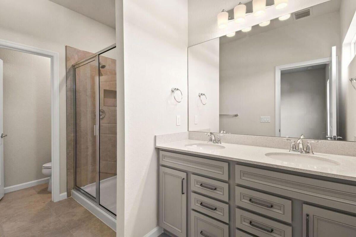 1805 Southeast Ocean Cove Way Stuart, FL 34996 - Photo 18 of 23 a bathroom with a double vanity sink and mirror