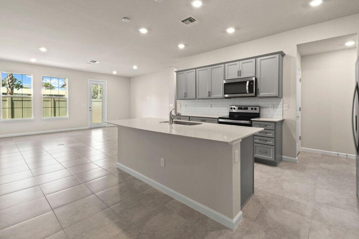 1805 Southeast Ocean Cove Way Stuart, FL 34996 - Photo 4 of 23 a kitchen with stainless steel appliances a stove a sink a refrigerator and a window