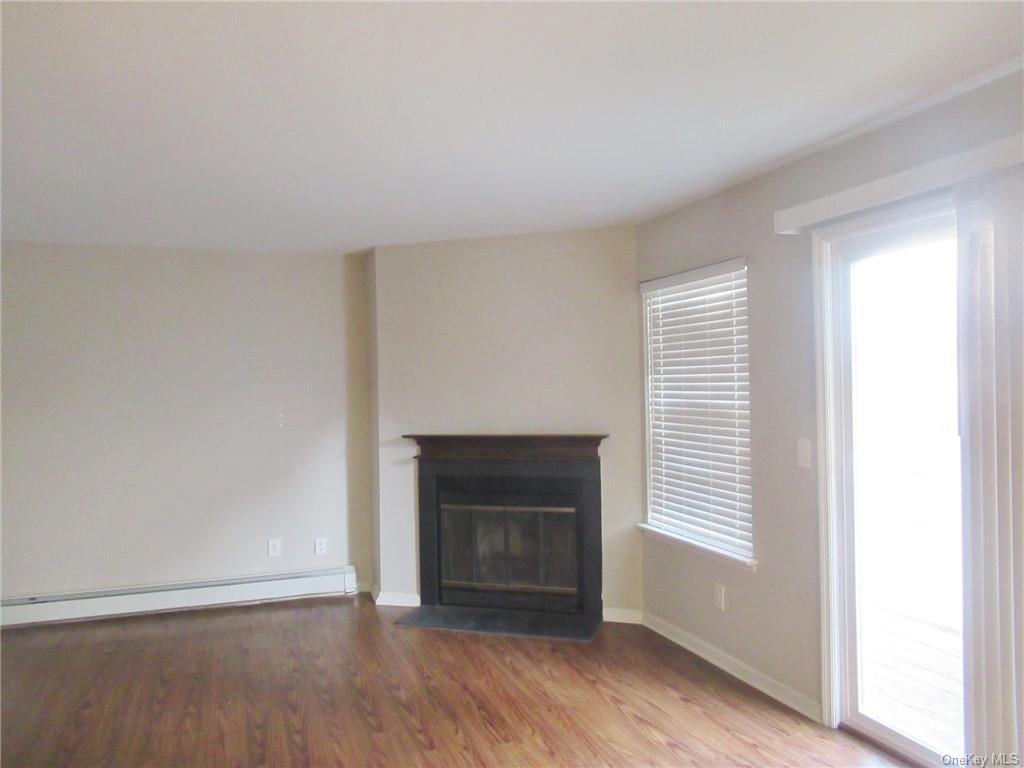 an empty room with windows and a fireplace