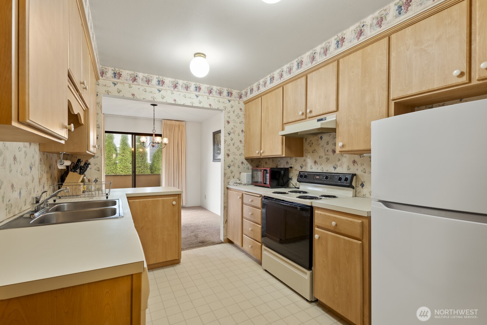 2510 Rucker Avenue, Unit 1 Everett, WA 98201 - Photo 17 of 34 a kitchen with stainless steel appliances granite countertop a refrigerator a stove a sink dishwasher and white cabinets with wooden floor