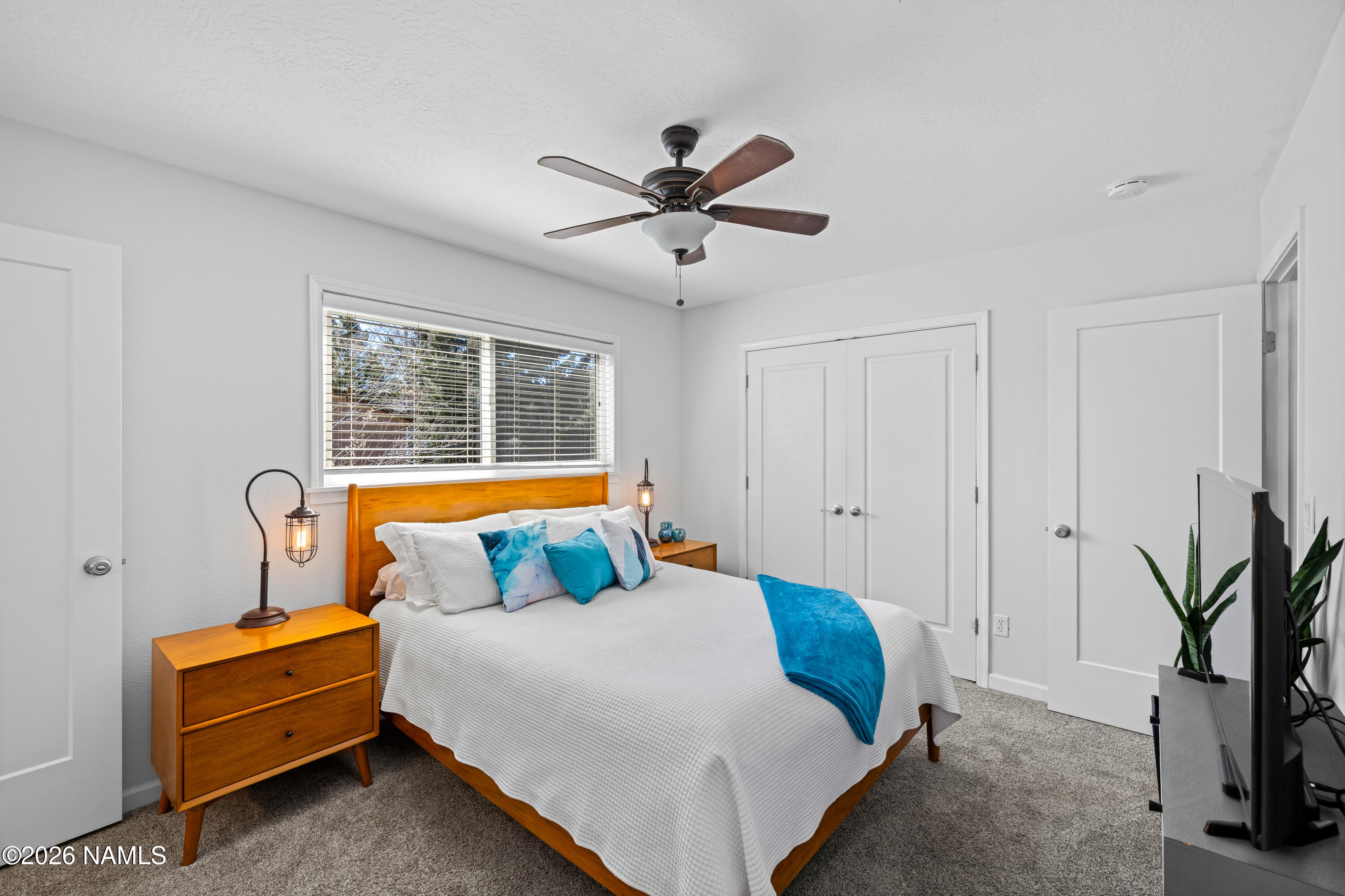 2536 East Eva Loop Flagstaff, AZ 86004 - Photo 18 of 37 a bedroom with a bed and a chandelier