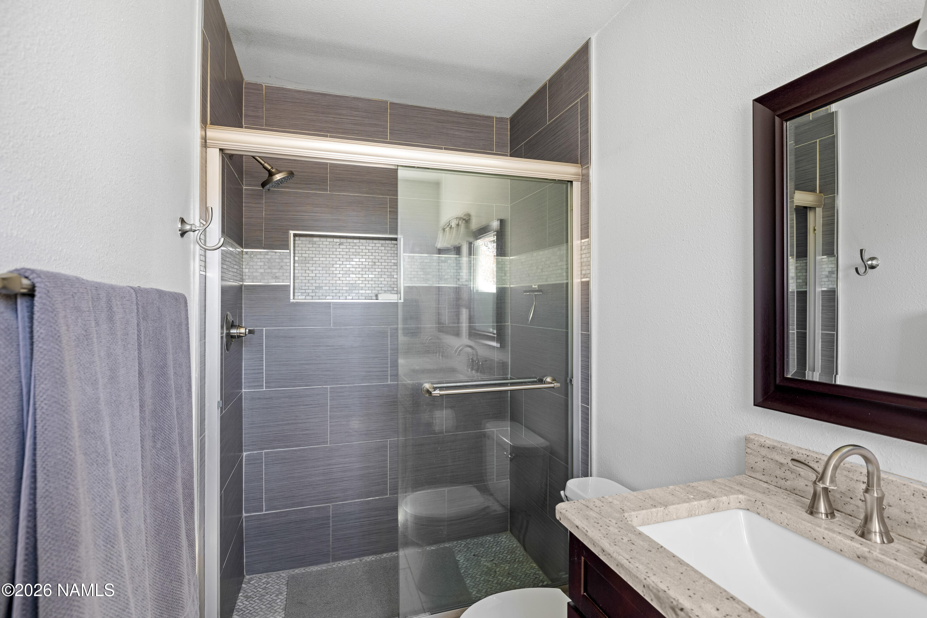 2536 East Eva Loop Flagstaff, AZ 86004 - Photo 21 of 37 a bathroom with a granite countertop sink a mirror and shower