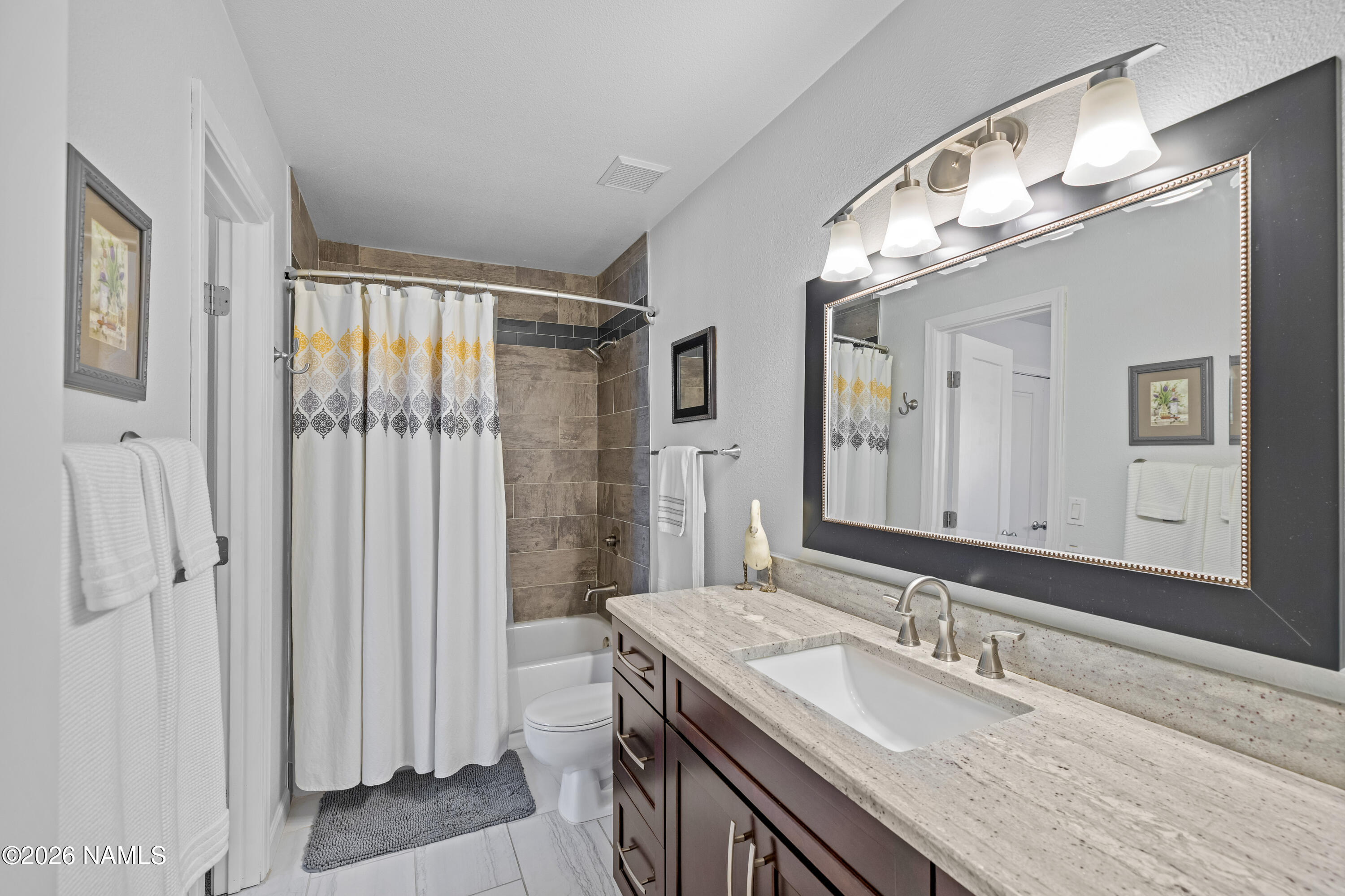 2536 East Eva Loop Flagstaff, AZ 86004 - Photo 25 of 37 a bathroom with a granite countertop sink a mirror and a shower