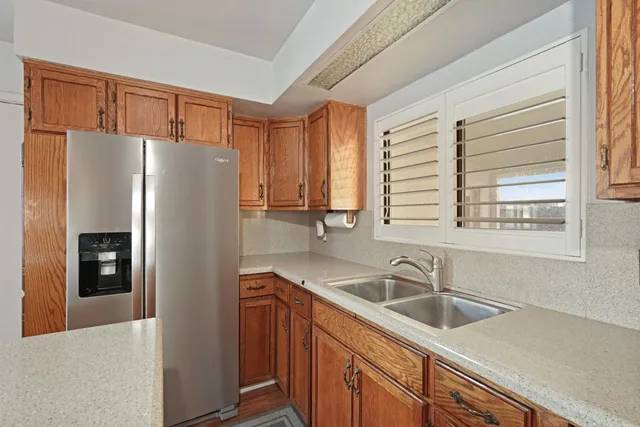 a kitchen with a sink a refrigerator and cabinets