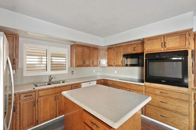 a kitchen with stainless steel appliances granite countertop a sink and a microwave