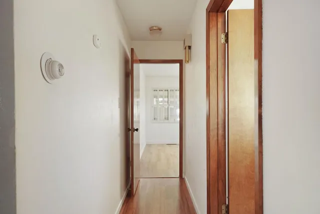 a view of a hallway with wooden floor